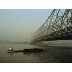  A Man Guides a Boat under a Bridge on the Hooghly River at 